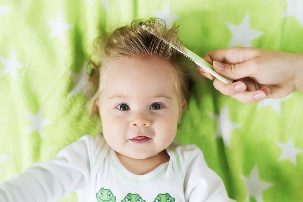 baby getting their hair combed