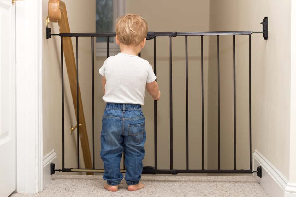 Child standing in front of a baby gate