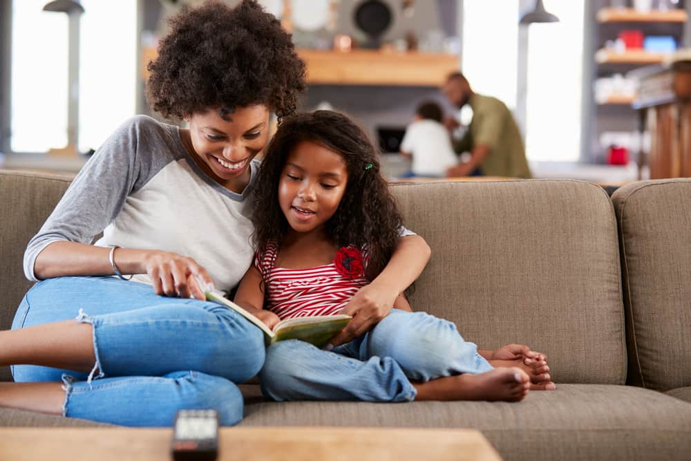 mom and daughter reading on couch