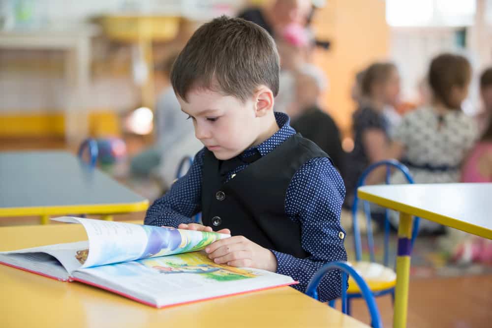 boy exploring book at his desk