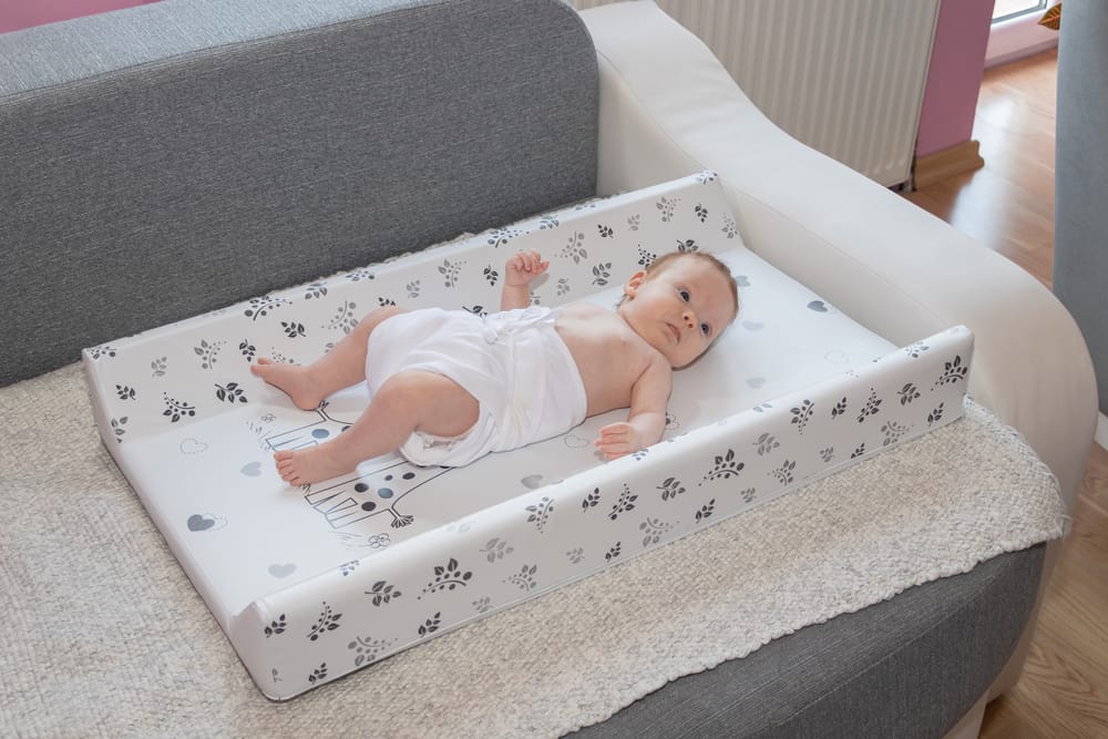 newborn baby laying down on changing pad