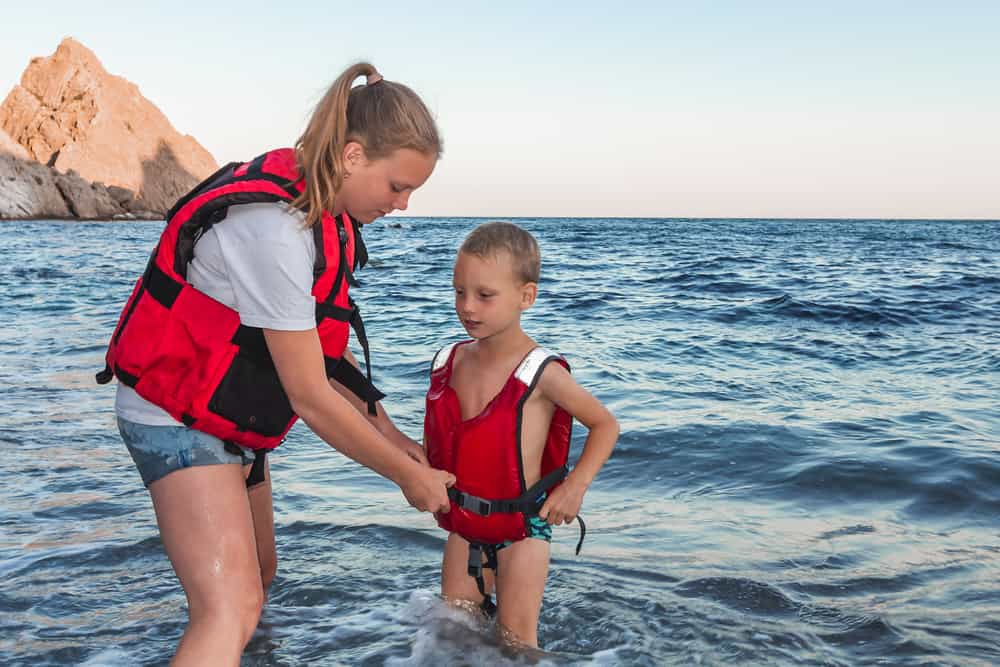 mother secures son’s life vest