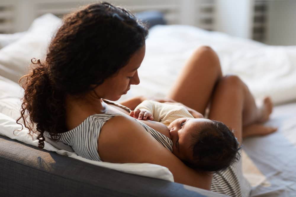 mother breastfeeding baby in bed