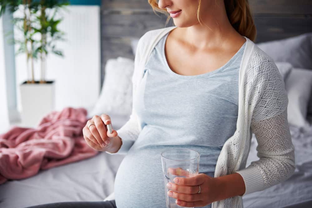 pregnant woman taking prenatal vitamins