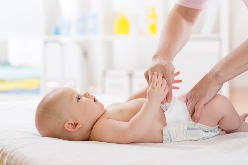 close up mom putting diaper on baby