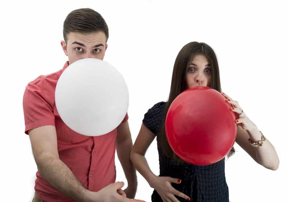 Couple blowing balloons for pregnancy announcement