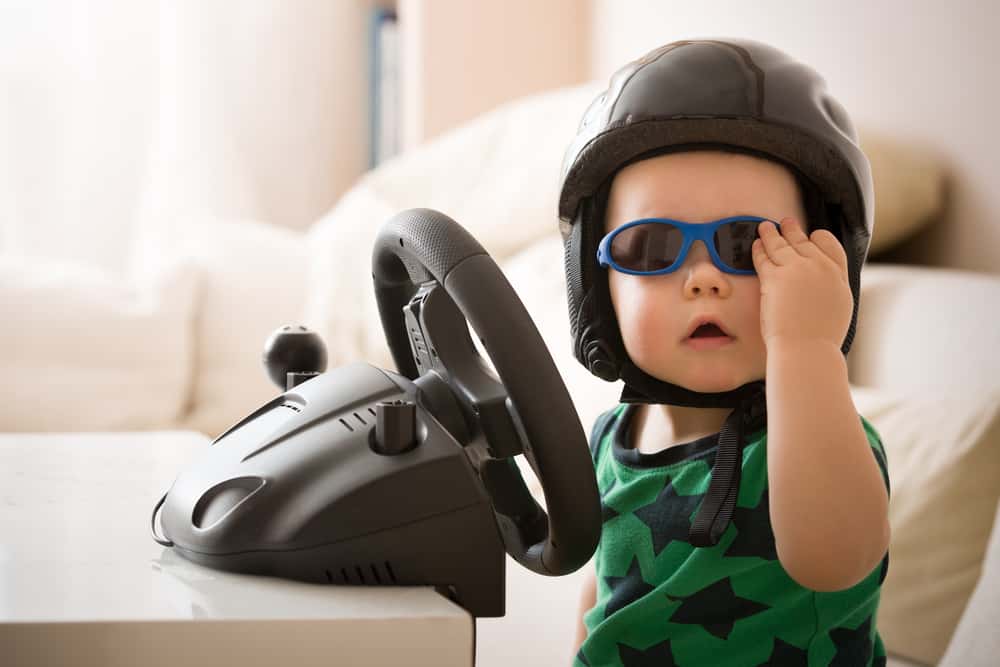 cute bab boy in sunglasses pretending to drive