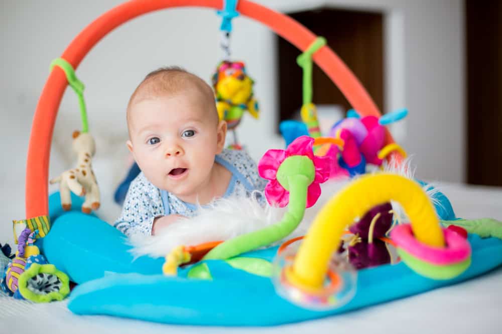 Cute baby boy on colorful gym