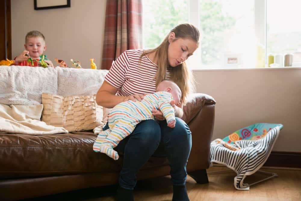 mom burping baby face-down on her lap