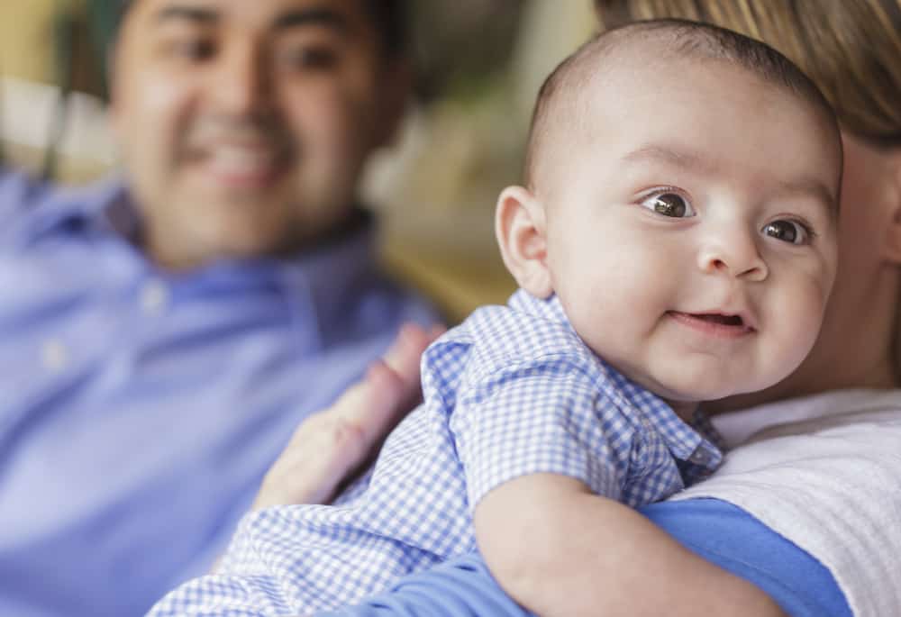 family burps their smiling baby