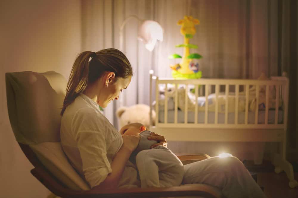 woman breastfeeding baby in nursery