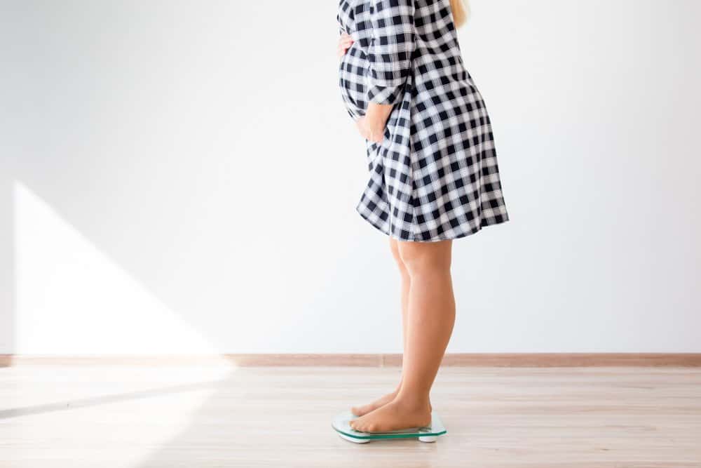 pregnant woman weighing herself