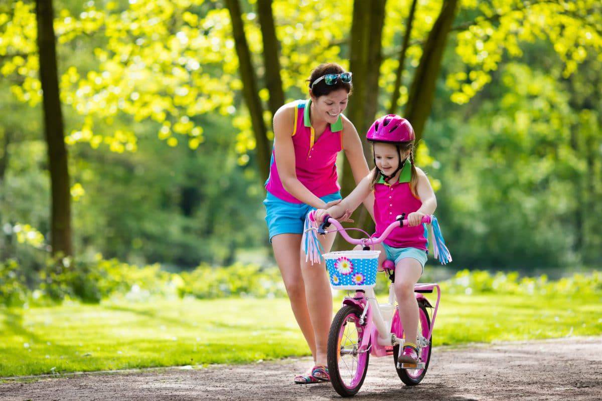 toddler riding a bike with her mom