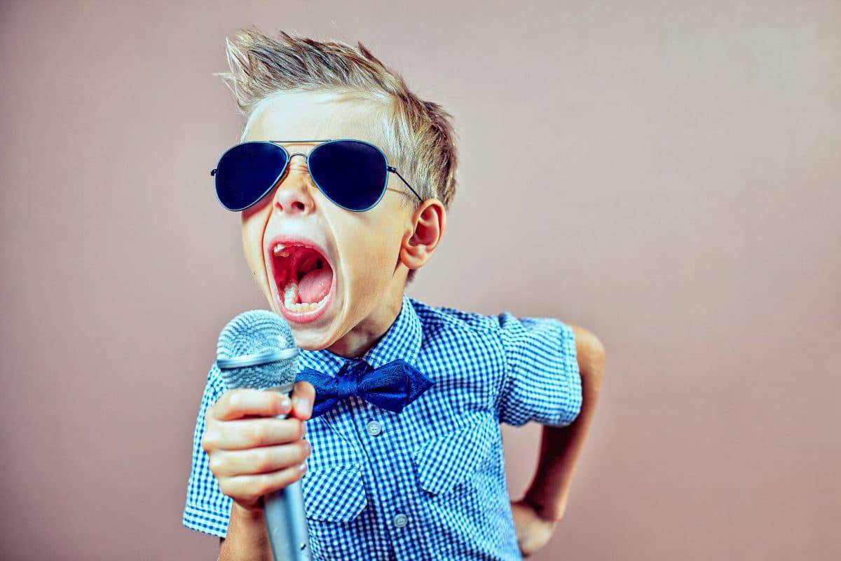 young boy singing into microphone