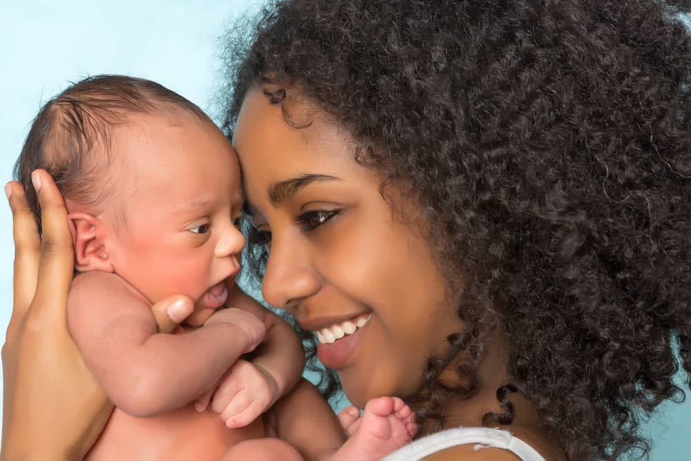 smiling mother with newborn baby