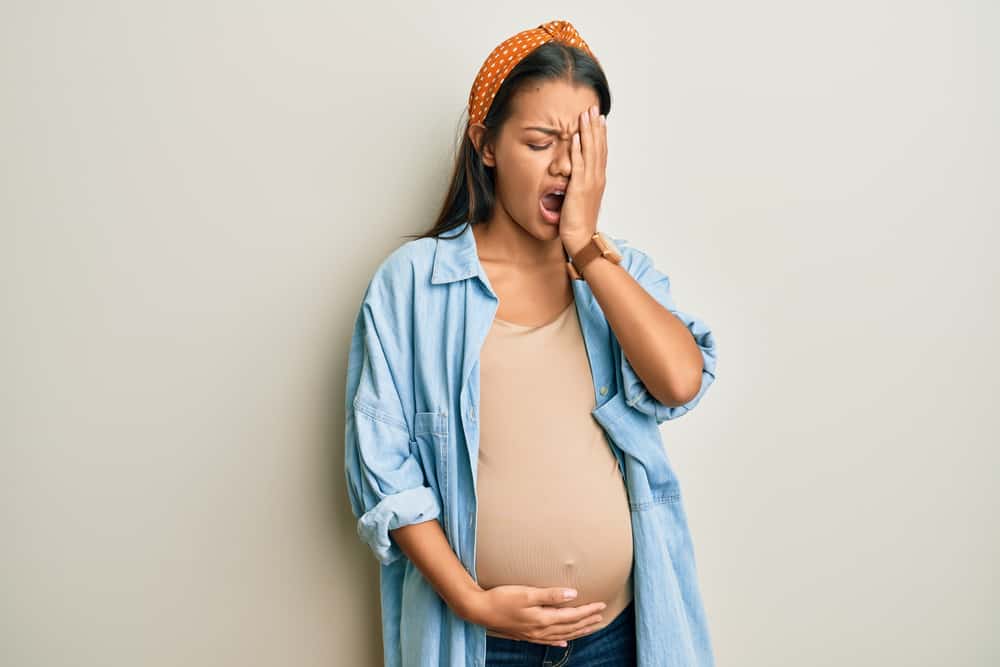 tired pregnant woman yawning