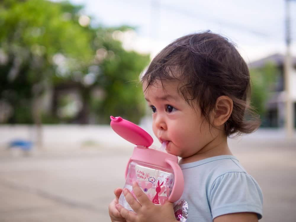 toddler drinking water outside