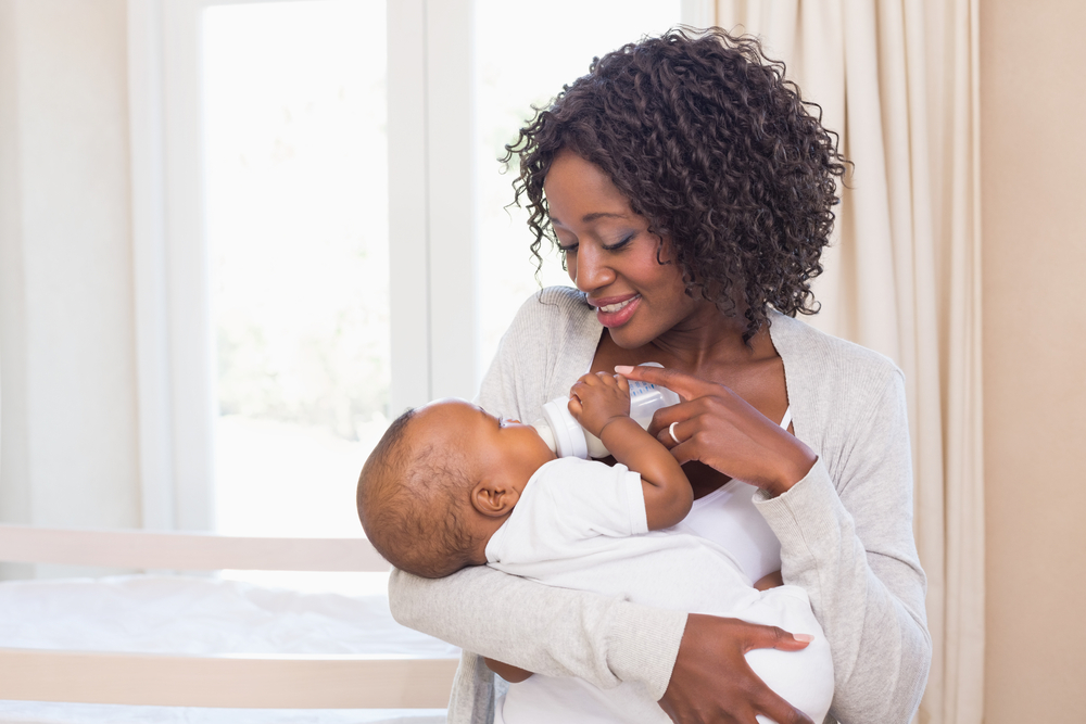 Young mother bottle-feeding her baby